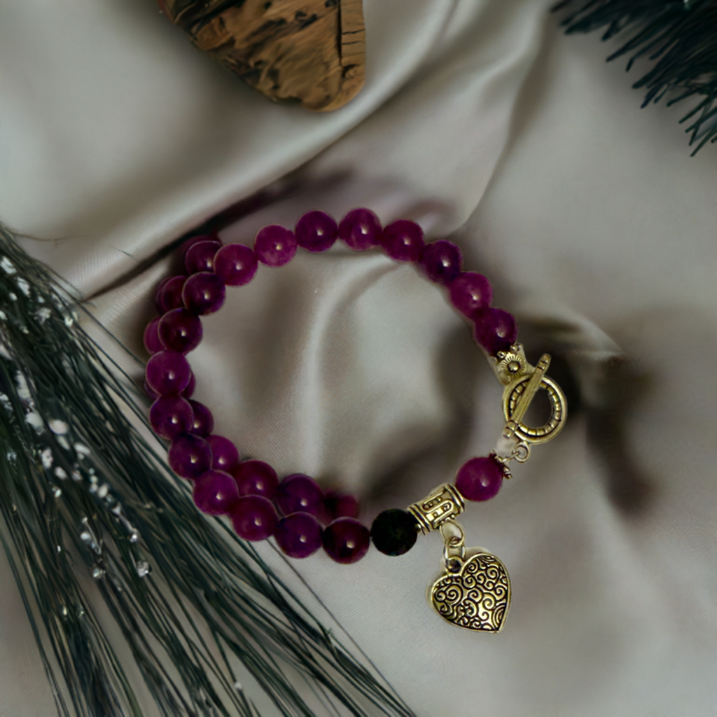Diffuser Bracelet with purple amethyst beads and silver  heart charm on cloth fabric background