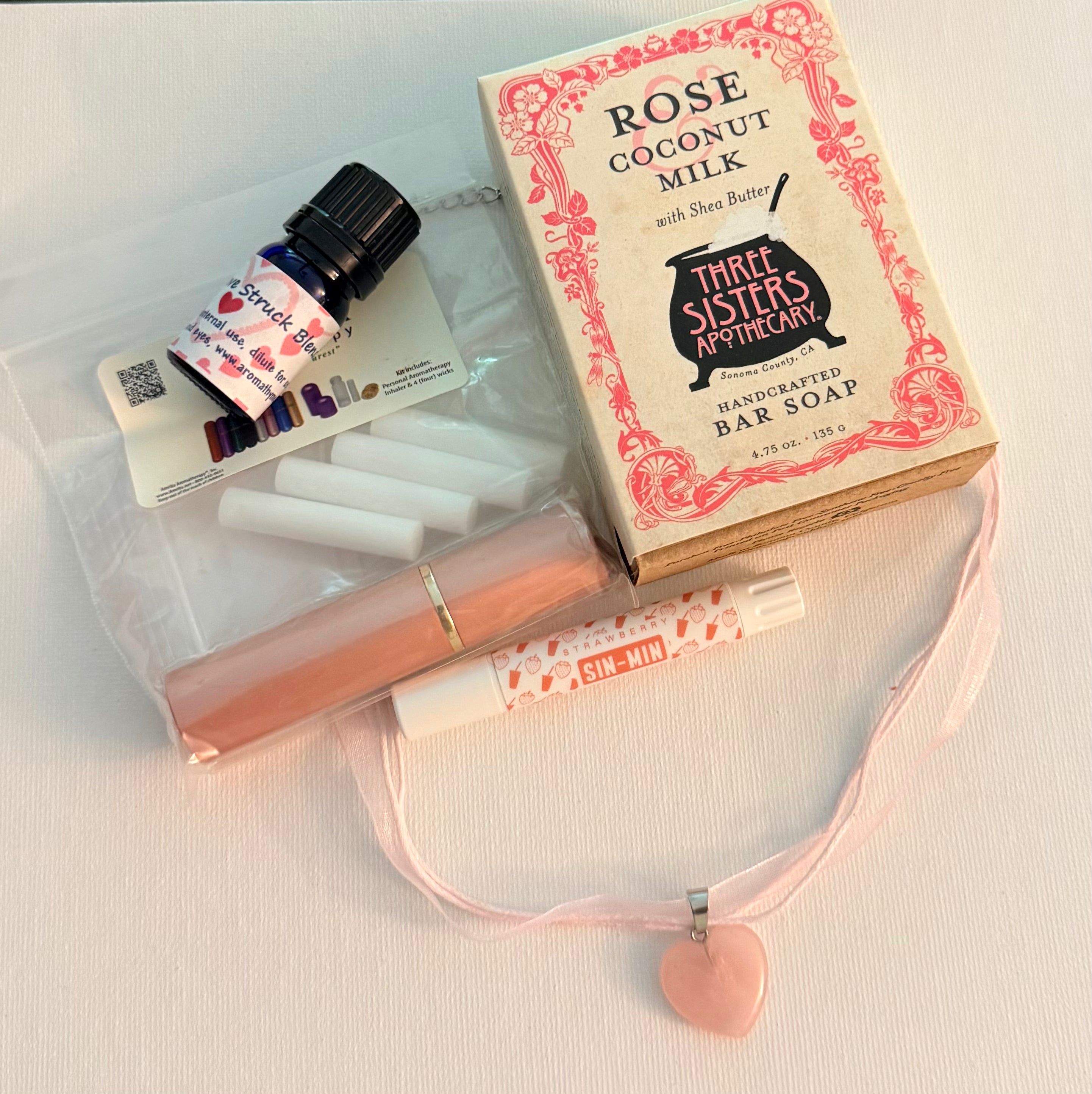Aromatherapy Gift set with Three Sisters Apothecary bar soap with lip balm, essential oil bottle, and necklace on a light background